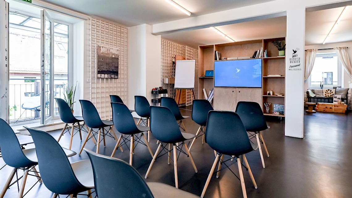 Row seating with a view of the movable TV wall of the OutOfOffice Glockenbachviertel