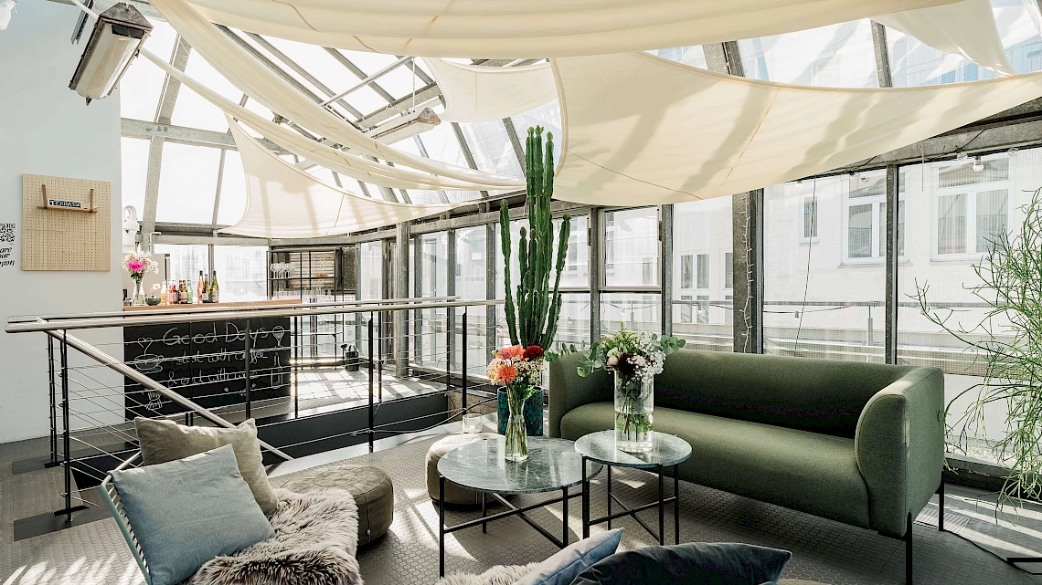 Wintergarten mit gemütlicher Lounge-Ecke im OutOfOffice Stuttgart