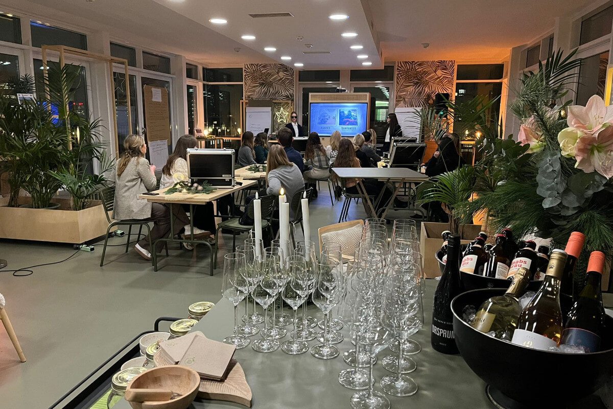 Teambuiding bei einer Quiz-Night in einer Eventlocation mit Leinwand und Stehtischen