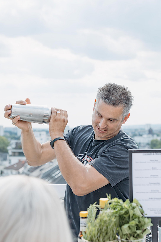 Barkeeper sch&uuml;ttelt einen Cocktailshaker bei einem Cocktail Workshop in Frankfurt